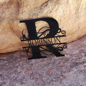 A photograph of a Black / 18" x 18" / Outdoor Split-letter Monogram by the metal art manufacturer Kraken Design Co.